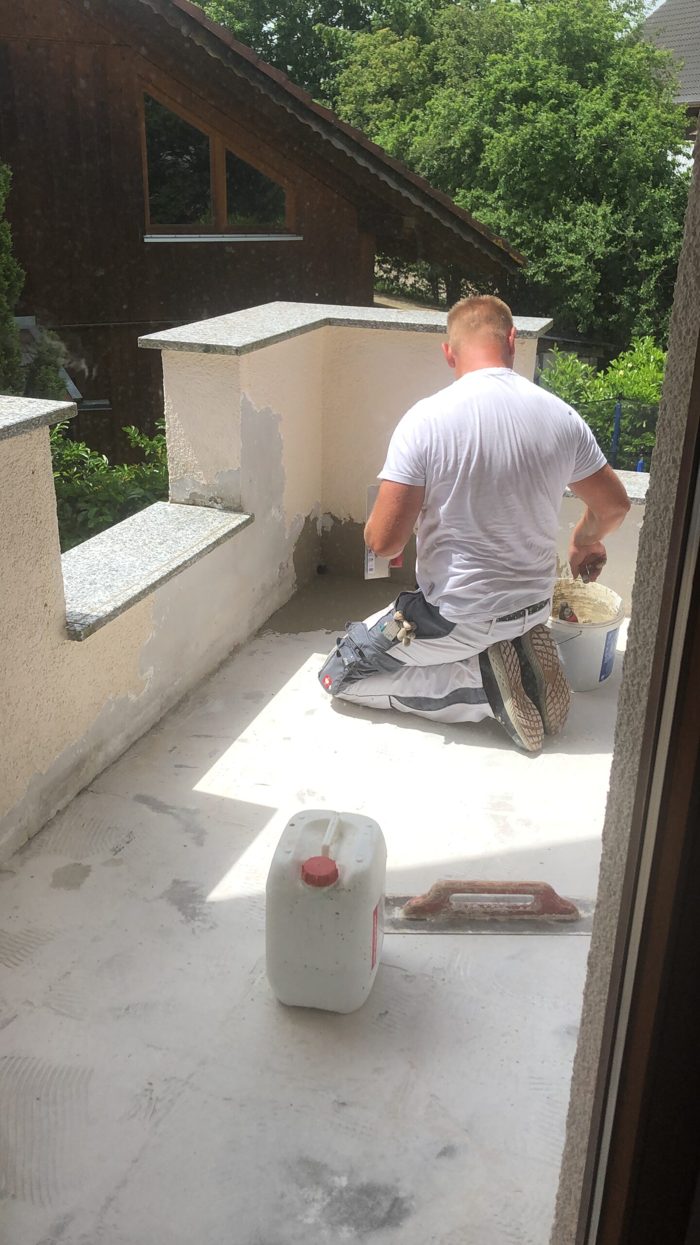 Handwerker Alexander Surow beim Tapezierenrenovieren eines Balkon in Volkertshausen